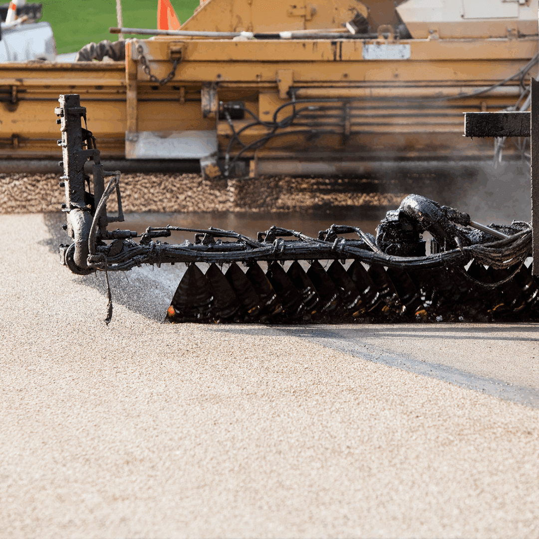 Road construction machinery laying asphalt surface.