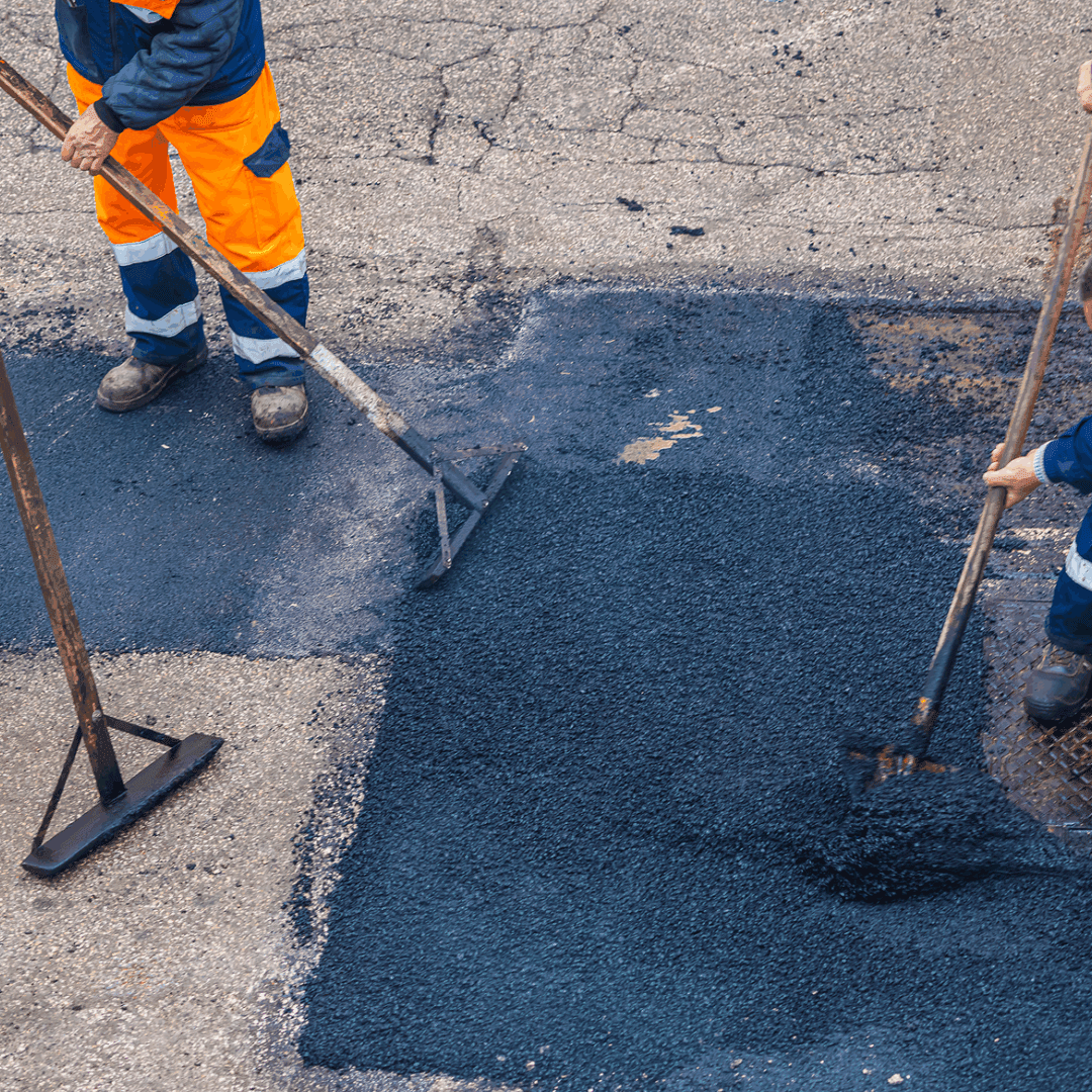 Workers repairing road with fresh asphalt.